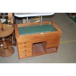 A wooden display case fitted six drawers