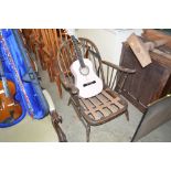 An Ercol stick back arm chair lacking cushions