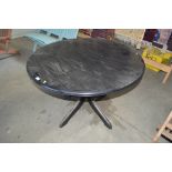 A black ash effect circular extending dining table
