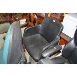 A faux leather upholstered swivel chair