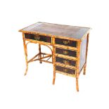 A late Victorian bamboo and lacquered single pedestal desk, leather inset top above five drawers all