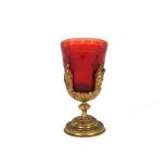 A 19th Century engraved ruby goblet, in gilt figure decorated stand, 17.5cm high; and a gilt