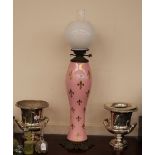 A Victorian porcelain and brass mounted oil lamp, having gilt Fleur de Lys decoration on a pink