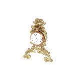 A yellow metal cased gents pocket watch, hung to a brass easel stand with cherub decoration