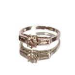 A white metal ring, set ½ carat diamond, flanked by baguette cut diamonds