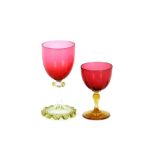 A set of six cranberry wine glasses, raised on green tinted clear glass stems, and frilled spread