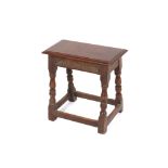 An oak joint stool, having carved frieze above turned baluster supports united by stretchers, 45cm