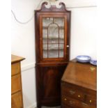 A 19th Century mahogany corner cupboard, the upper shelves enclosed by a single glazed panel door