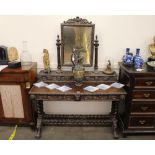 An ornate Victorian carved oak dressing table, having lion mask and foliate decoration, the raised