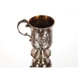 A Victorian silver baluster christening mug, with raised foliate embossed decoration and central