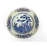 A large 18th Century Chinese blue and white plate, decorated with rural scene depicting deer and