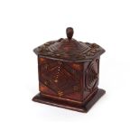 A Folk Art spice box, having raised floral decoration and stepped lid, surmounted by a finial,