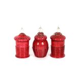 A pair of cranberry glass lidded jars, the domed lids with clear glass knop finials, ribbed