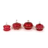 Four various cranberry and clear glass mounted bowls and covers