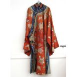 An antique Chinese Mandarin cloak, having flower, butterfly and symbol decoration on a peach