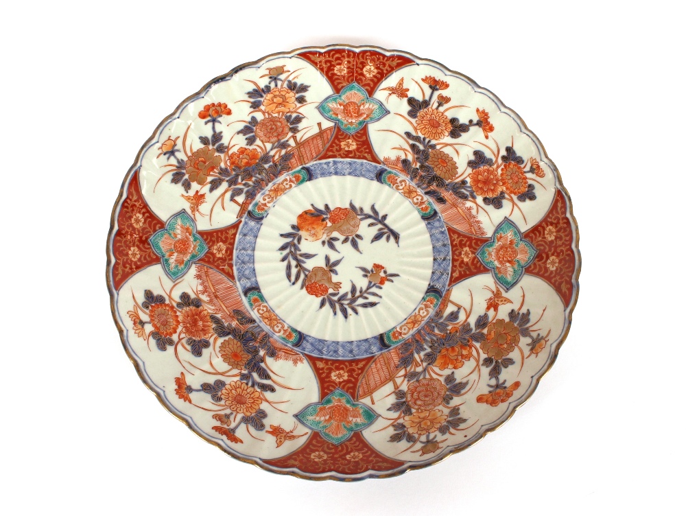A large Japanese Imari charger, having scallop border decorated in the traditional manner,