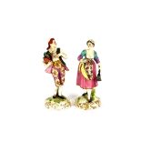 A pair of Derby porcelain figures, of a couple in brightly coloured enamel dress, the man carrying a