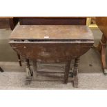 An 18th Century oak gate leg tea table, the rounded drop leaves raised on single end turned column