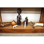 A collection of various miscellaneous wooden items, including native figure, model of a canoe,