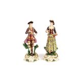 A pair of continental porcelain figures, depicting lady and gallant shooting, both wearing
