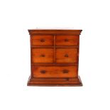 An Edwardian small pine table chest, of four short and one long drawer, raised on a stepped