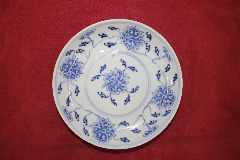 An 18th Century Chinese saucer dish, decorated in under glaze blue with flower heads - Image 3 of 6
