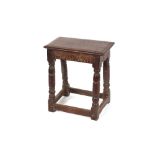 An antique oak joint stool, having carved frieze raised on turned baluster supports, 47cm wide