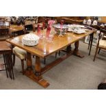 A good quality light oak refectory dining, table raised on turned baluster supports and block