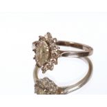 An 18ct white gold and diamond cluster ring, set central oval diamond, 3gms total weight