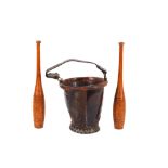 An antique leather fire bucket; and a pair of vintage wooden Indian clubs