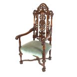 A Victorian carved oak elbow chair, having profuse pierced foliate back, scrolled acanthus arms