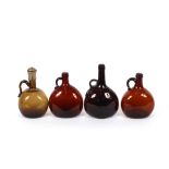 A collection of nine 19th Century amber and brown glass claret flagons, some with plated mounts