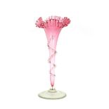 A cranberry glass trumpet shaped posy vase, with frilled rim and clear glass trailing foliage,