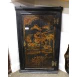 A George III lacquered and chinoiserie decorated hanging corner cabinet, the hinged door depicting