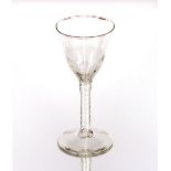 An antique wine glass, with half fluted tapering bowl on cotton twist spiral stem raised on circular