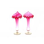 A pair of cranberry tinted Jack in the Pulpit vases, raised on clear glass circular spread feet,