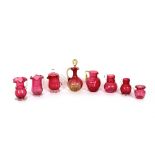 A collection of various cranberry glass baluster jugs, including one covered example; and an oil