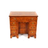 A walnut and herringbone banded kneehole writing desk, in the 18th Century style fitted single