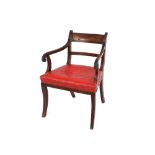 A Regency mahogany elbow chair, having reeded bar back, leather upholstered seat raised on sabre