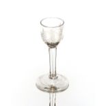 An antique wine glass, the bowl with etched decoration of birds and foliage on clear stem and