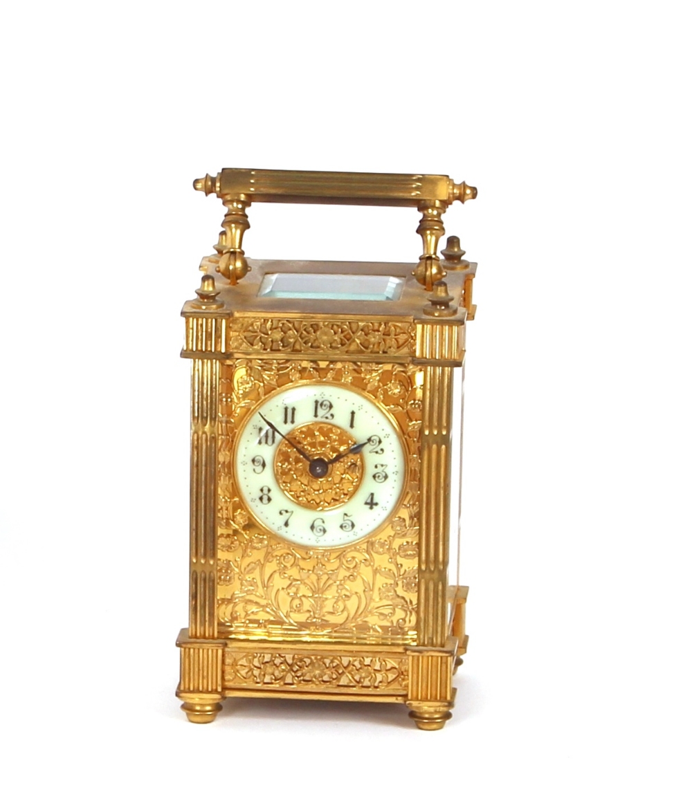 A gilded brass carriage timepiece, having richly decorated filigree panels and foliate chased
