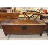 An antique oak coffer, of narrow proportions, the lid with iron strap hinges above a square lock