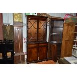 A reproduction mahogany and glazed bookcase raised