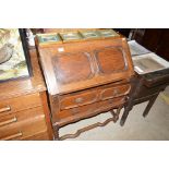 An oak geometric moulded bureau, fitted two long d