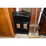 An Arts and Crafts ebonised corner cupboard decora