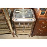 A mirrored glass and gilt decorated bedside chest