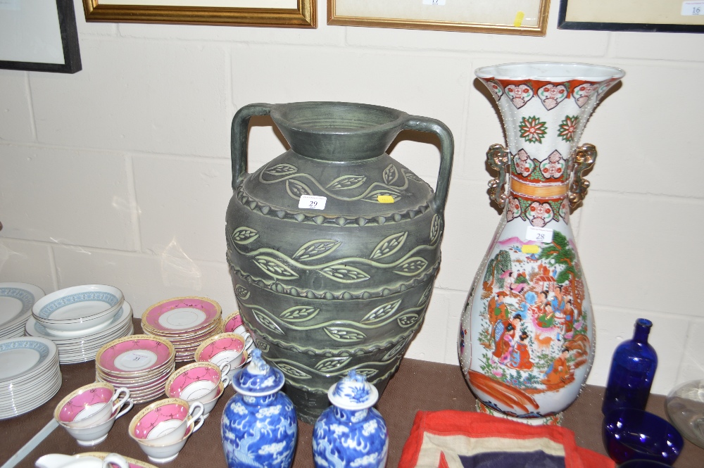 A large pottery green glazed twin handled vase