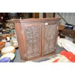 A carved oak hanging corner cupboard