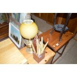 A carved hardwood candle box and a brass oil lamp
