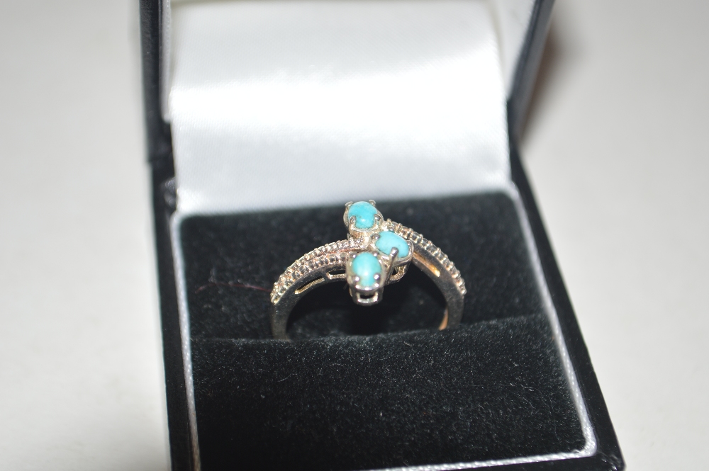 A 925 silver and turquoise set cross over ring